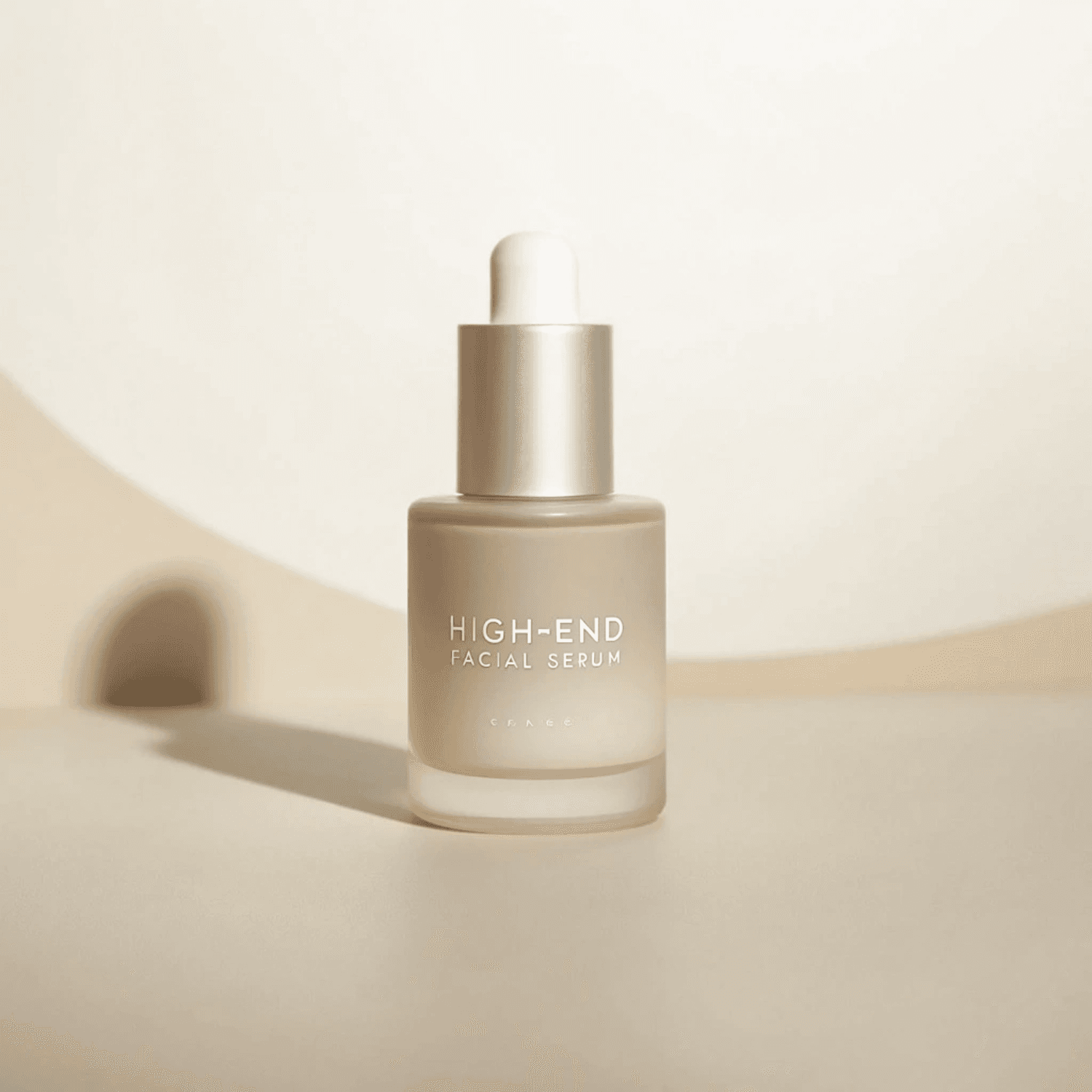 Frosted glass serum bottle with a silver cap on a soft beige background